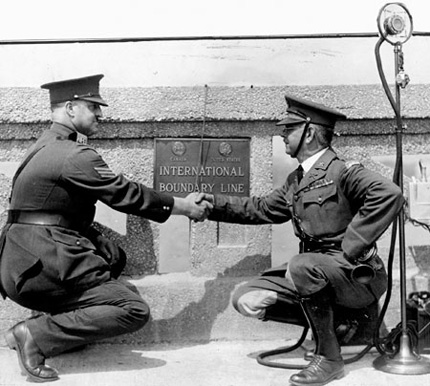 Border ties: Sergeant R. Cox, (left), representing Canada, and Lieutenant Oscar Haffa, representing the United States, clasp hands at the international border on the new Peace bridge between Fort Erie, Ontario and Buffalo, New York, in 1927. 