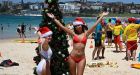 Thousands dressed in festive beach outfits flock to Bondi Beach and Byron Bay to celebrate Christmas